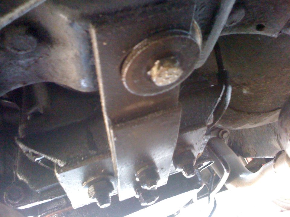 Close-up of metal brackets and bolts on a vehicle's undercarriage