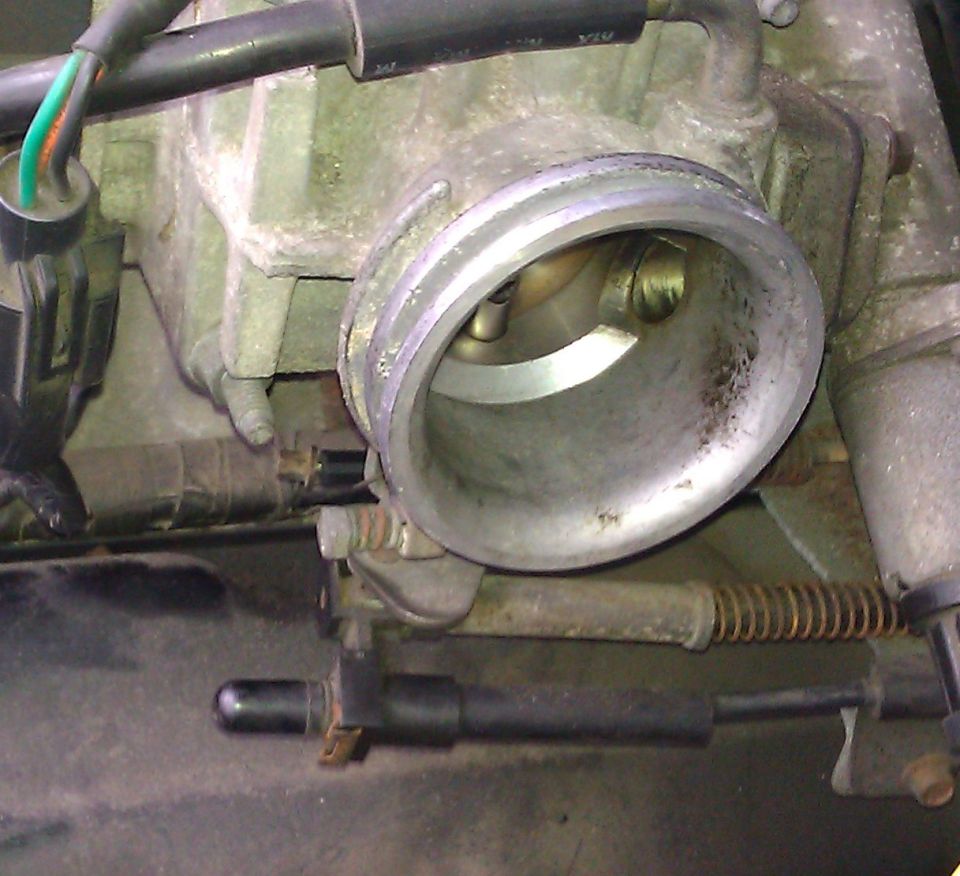 Close-up of an open throttle body throttle bore on a removed assembly
