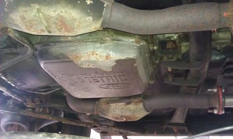 1991 Mercury Grand Marquis - Underside view of a vehicle's transmission and exhaust components, showing some rust and wear.