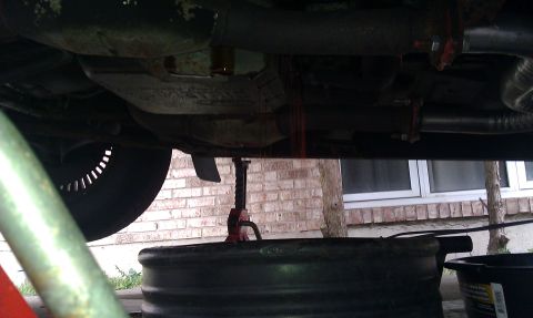 1991 Mercury Grand Marquis - Transmission fluid drains from the undercarriage of a vehicle into a collection pan.