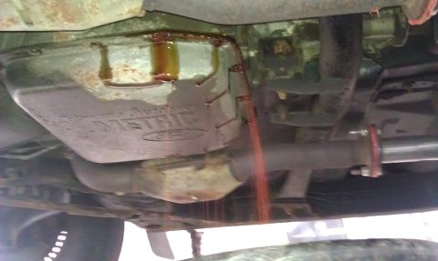 1991 Mercury Grand Marquis - Transmission fluid draining from the pan. The pan has "METRIC" stamped on it.