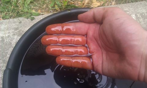 1991 Mercury Grand Marquis - A hand with fingers submerged in dark fluid within a black pan, with the Supermotors.net logo in the corner.