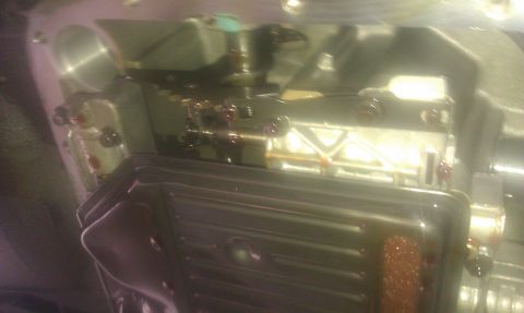 1991 Mercury Grand Marquis - Close-up view of a transmission pan and valve body, likely during a fluid change or repair.