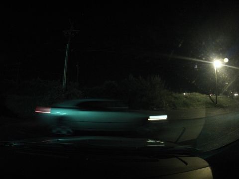 2003 Ford Taurus - Car driving at night, motion blur visible on the vehicle and road surface.