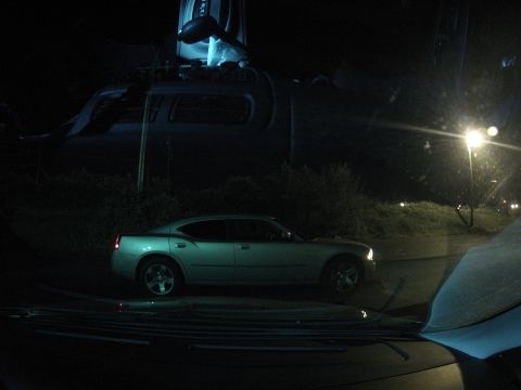 2003 Ford Taurus - A silver sedan is parked on the side of the road at night.
