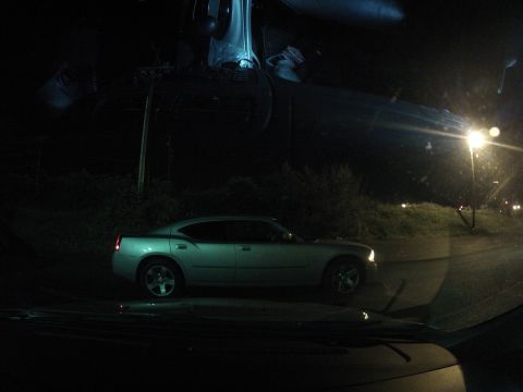 2003 Ford Taurus - Silver sedan parked on a wet road at night under an overhead structure.