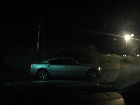 2003 Ford Taurus - A silver sedan is parked on the side of the road at night.
