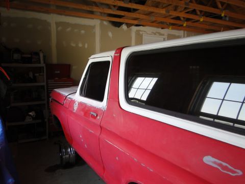 1978 Ford Bronco - A red and white 1978 Ford Bronco is shown in a garage, appearing to be in the process of restoration.