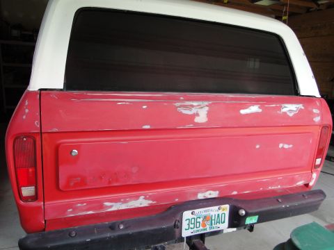 1978 Ford Bronco - Rear view of a 1978 Ford Bronco in need of restoration, displaying its red body, white top, and a Florida license plate.