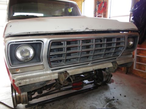 1978 Ford Bronco - Front end of a white truck, showing the grille and suspension components, in a workshop setting.
