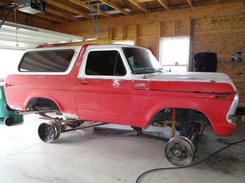 1978 Ford Bronco - 1978 Ford Bronco undergoing restoration work in a garage, missing its wheels.