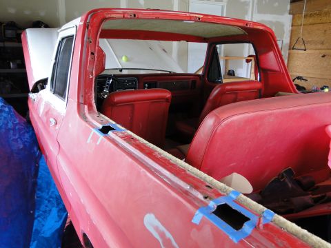 1978 Ford Bronco - The interior of a red 1978 Ford Bronco, showing red seats and dashboard, is visible as the vehicle undergoes restoration.