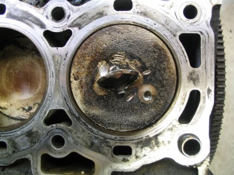 1997 Ford Taurus - Close-up of a damaged engine cylinder head, showing a bent valve and carbon buildup.