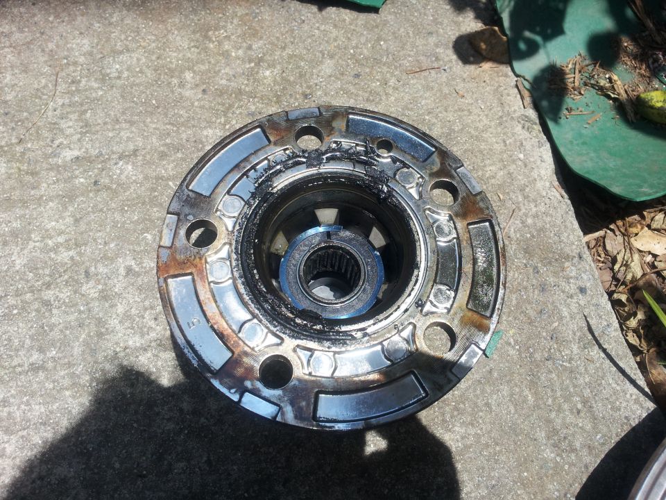 Disassembled hub assembly with grease and blue snap ring on concrete