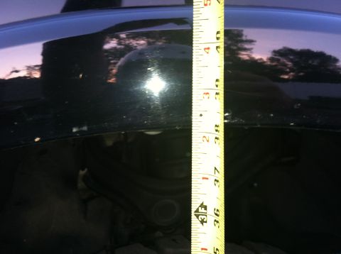 2005 Ford Explorer - A tape measure is used to gauge a measurement on the vehicle's suspension system.