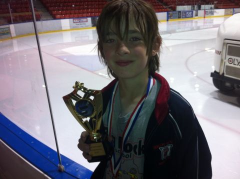 1965 Ford Fairlane - A young boy proudly holds his trophy after an event at an ice rink.