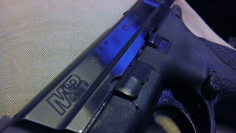 2000 Mercury Grand Marquis - A close-up view of a black handgun with "M&P" engraved on its slide.