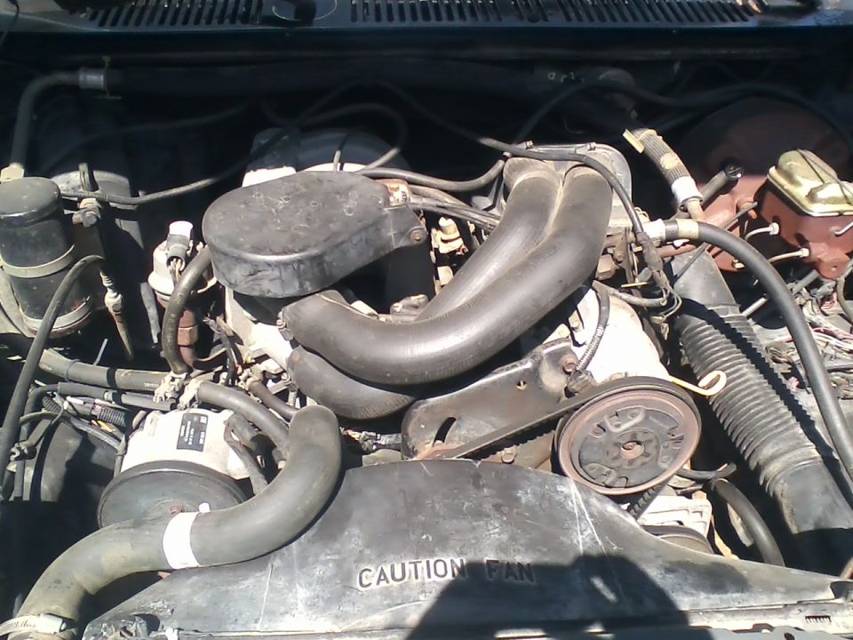 Engine bay with V-shaped intake manifold and "CAUTION FAN" shroud