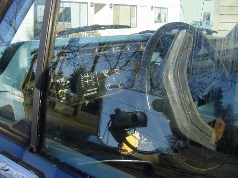 1987 Ford Bronco - The dashboard gauges and steering wheel are visible through the window of a blue vehicle.