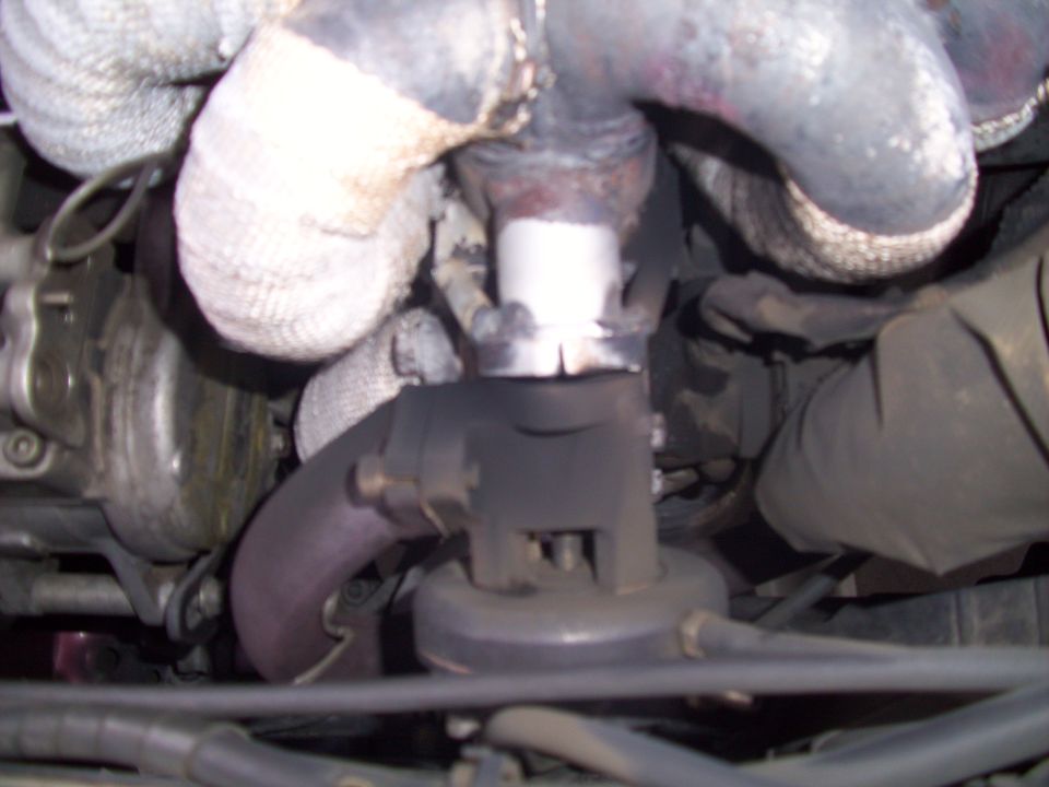 Close-up of exhaust manifold pipes and turbocharger assembly with heat wrap
