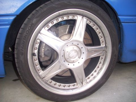 1995 Ford Probe - Close-up of a car's wheel and brake assembly, showing a 'CORVE' caliper and a silver rim.