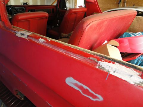 1978 Ford Bronco - The interior of a red 1978 Ford Bronco shows red seats and unfinished bodywork.
