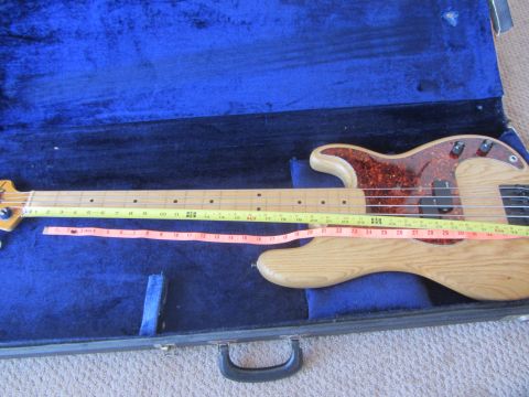1968 Ford Mustang - A Fender Precision Bass guitar is shown in its blue velvet-lined case with measuring tapes laid across it.