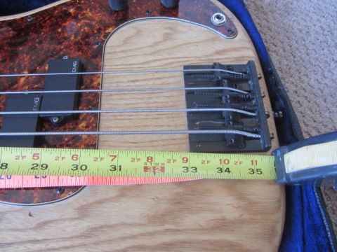 1968 Ford Mustang - A tape measure is placed across the bridge of a bass guitar, showing measurements from 30 to 35 inches.