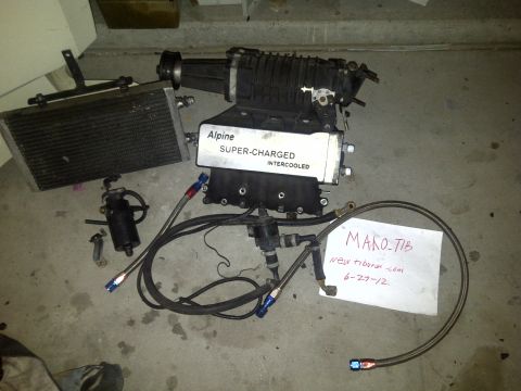 2003 Hyundai Tiburon - Supercharger and intercooler assembly, likely for a Hyundai Tiburon, with associated plumbing and an oil cooler.