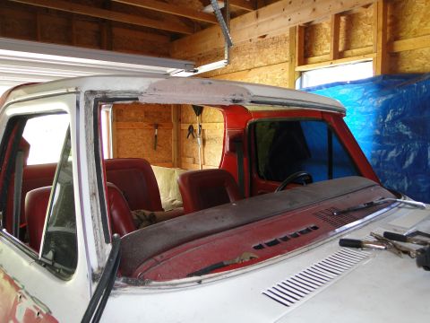 1978 Ford Bronco - The interior of a vintage Ford truck, likely from the 1970s, is visible with its windshield removed.
