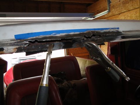 1978 Ford Bronco - Working on a rusted metal edge with clamps inside a vehicle.