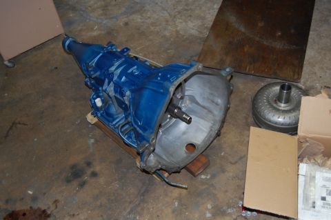 1985 Mercury Grand Marquis - A rebuilt automatic transmission and its torque converter sit on a garage floor.