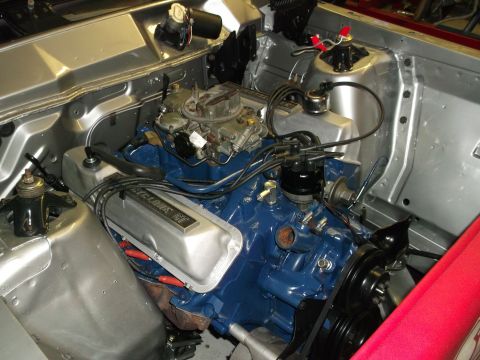 1967 Mercury Cyclone - The engine bay of a 1967 Mercury Cyclone features a blue engine with silver valve covers and a prominent carburetor.