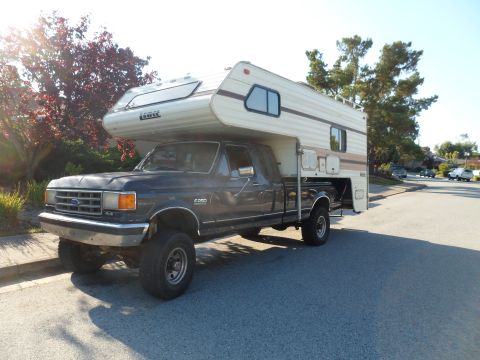1991 Ford Bronco - This Ford F-250 pickup truck is equipped with a camper shell, seen from a 3q-front angle.