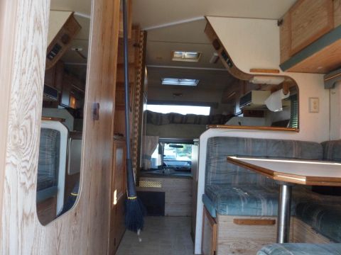 1991 Ford Bronco - Interior view of a camper van with seating, cabinets, and a broom visible.