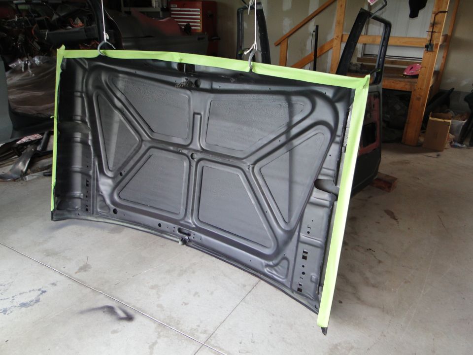 Underside of a car hood, taped for painting