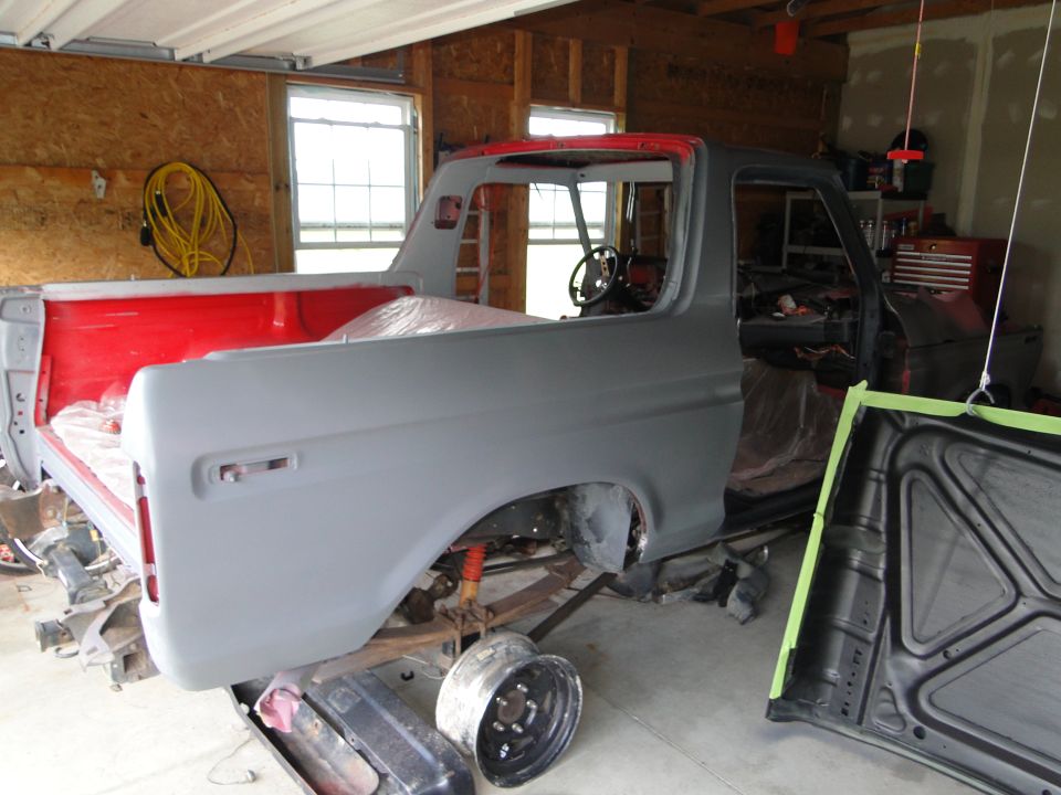 1978 Ford Bronco body in primer, undergoing restoration in a garage