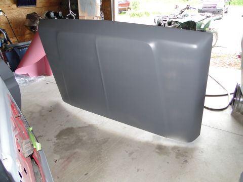 1978 Ford Bronco - A vehicle hood, covered in gray primer, is shown in a workshop setting.