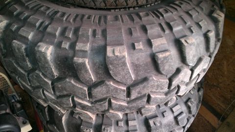 1978 Ford Bronco - A close-up view of a stack of off-road tires, showing their deep tread pattern.