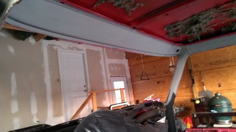1978 Ford Bronco - Vehicle interior showing red ceiling and insulation, in a garage setting during repairs.