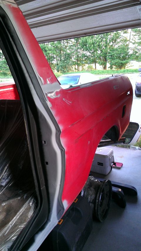 1978 Ford Bronco - A vehicle's rear quarter panel and door jamb are shown undergoing repair work in a garage setting.