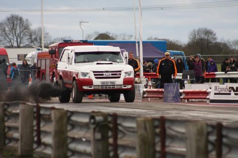 1989 Ford Bronco - A modified SUV is seen on a drag strip, emitting a large cloud of black smoke as it accelerates.
