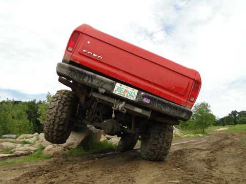 1978 Ford Bronco - This red 1978 Ford Bronco navigates a challenging rocky terrain, its off-road capabilities.