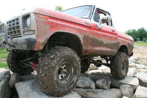 1978 Ford Bronco - This modified pickup truck is navigating a rocky obstacle course, showing off its off-road capabilities.