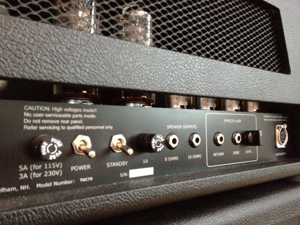 Back of a TU C75 amplifier with speaker outputs, effects loop, and power/standby switches