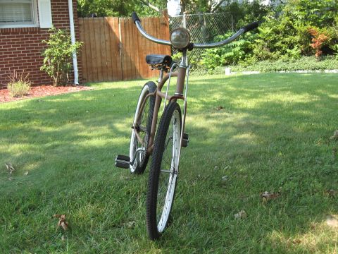 1994 Ford Bronco - A vintage-style bicycle with a brown frame and wide handlebars is parked on a grassy lawn.