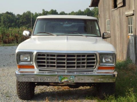 1978 Ford Bronco - Front view of a 1978 Ford Bronco parked next to a wooden building.