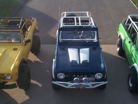 1977 Ford Bronco - Three Ford Broncos are lined up, each modified with a roll cage and off-road tires.