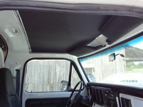 1978 Ford Bronco - Interior view of a white truck cab, revealing the dashboard and headliner details.