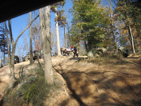 1987 Jeep Comanche - Multiple off-road vehicles navigate a wooded trail during an outing.